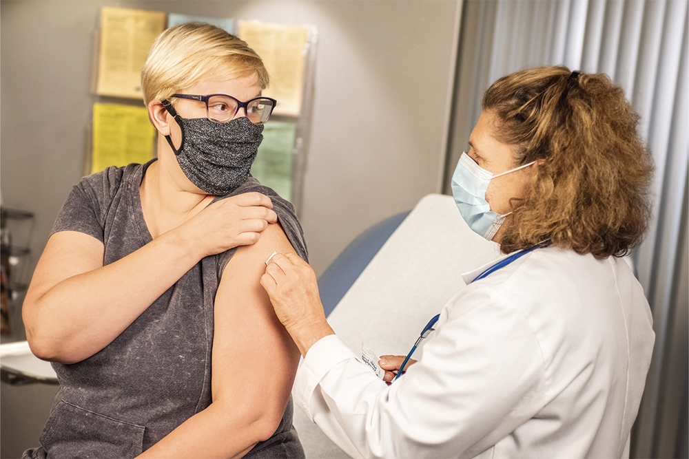 Woman getting vaccine from doctor