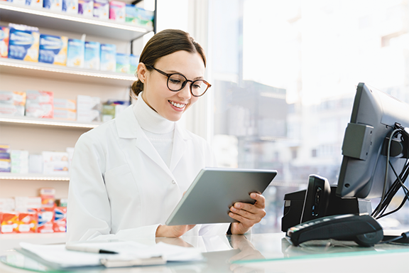 Smiling pharmacist using tablet computer