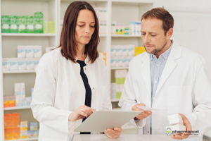 Two concerned looking pharmacists looking at tablet