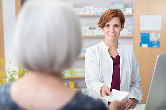 A smiling female pharmacists talking to a patient