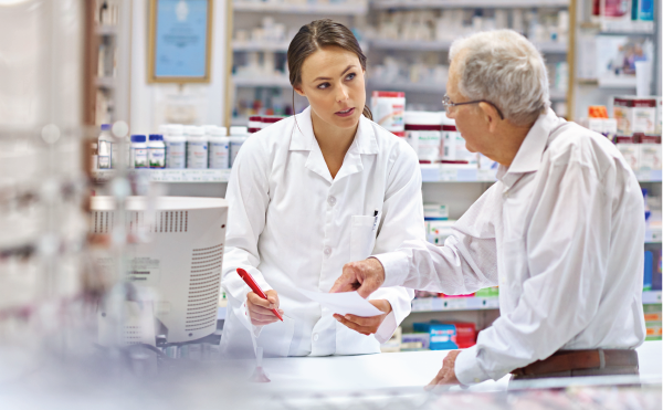 Female pharmacist speaking to elderly male patient