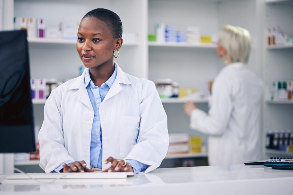 Smiling pharmacist using computer
