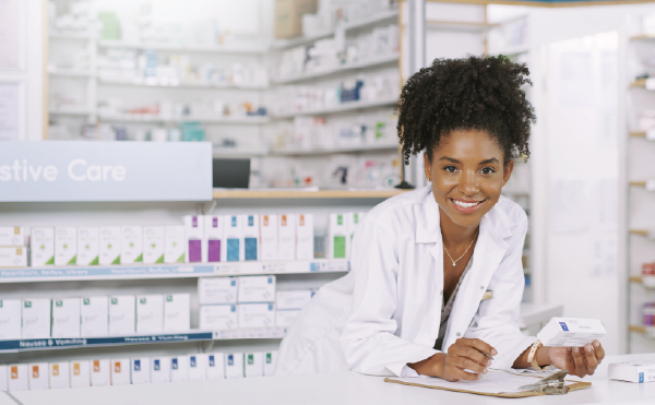 Smiling female pharmacists leaning on counter